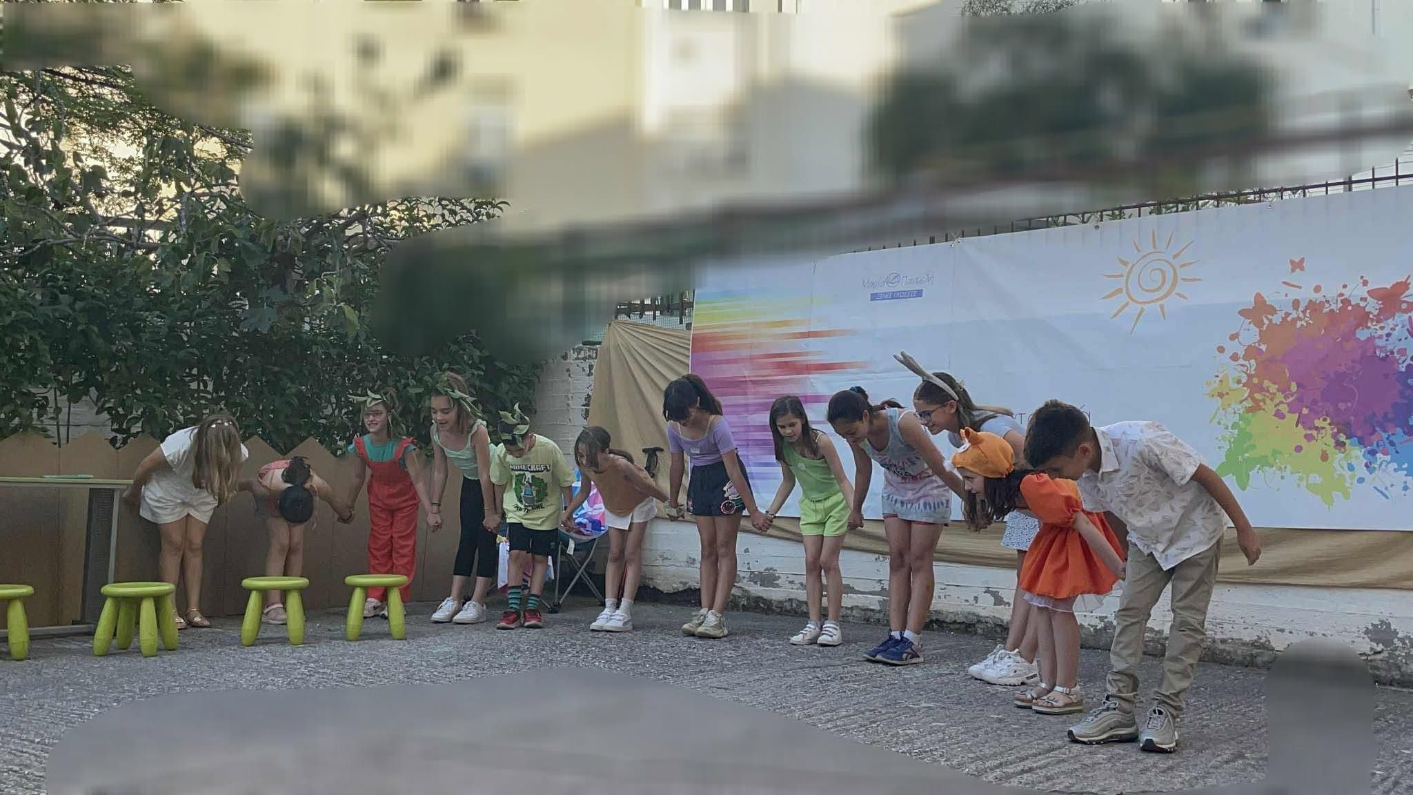 Μαθητές υποκλίνονται στο τέλος σχολικής παρουσίασης στο προαύλιο.