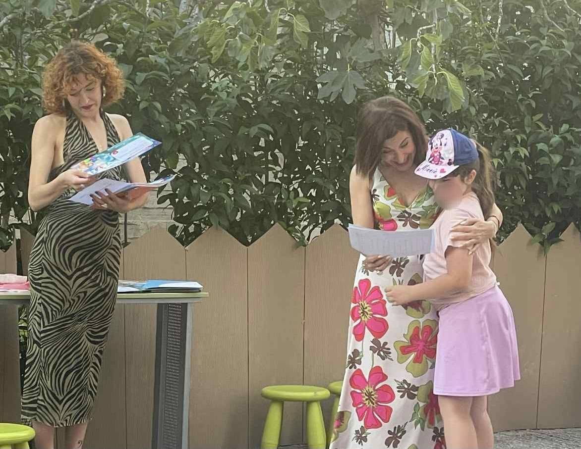 Μαθήτρια παραλαμβάνει αναμνηστικό από εκπαιδευτικό.