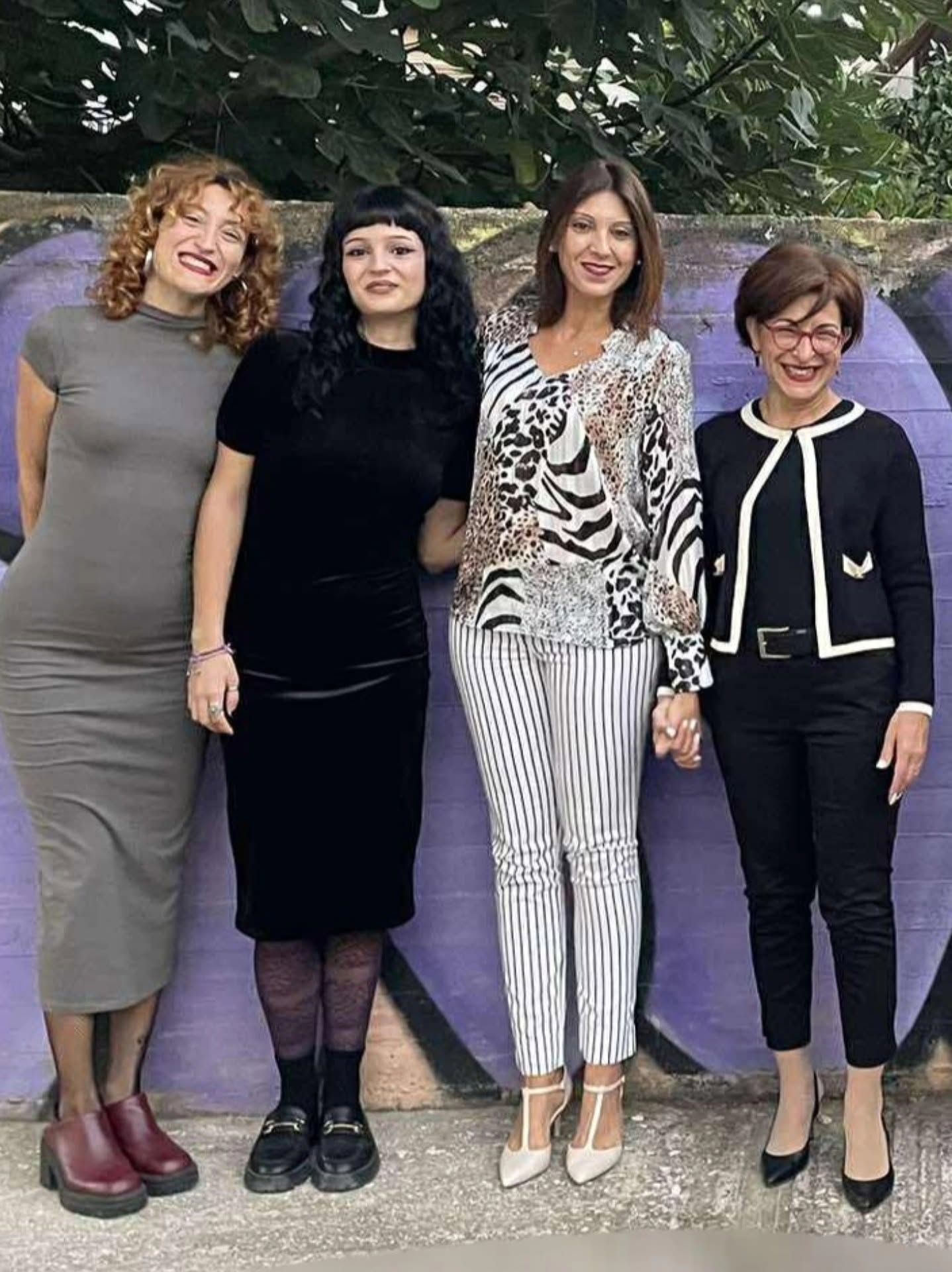 Τέσσερις εκπαιδευτικοί ποζάρουν στον προαύλιο χώρο.
