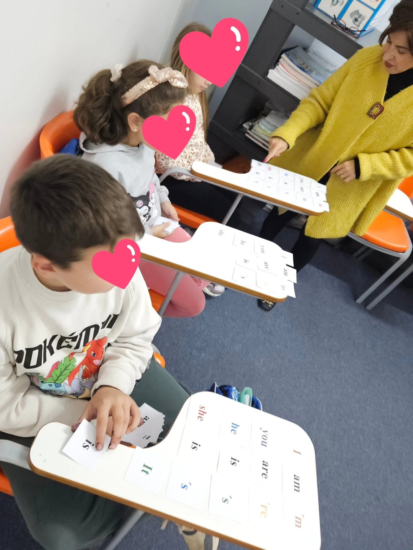 Μαθητές εργάζονται μαζί σε επιτραπέζια γλωσσική δραστηριότητα.