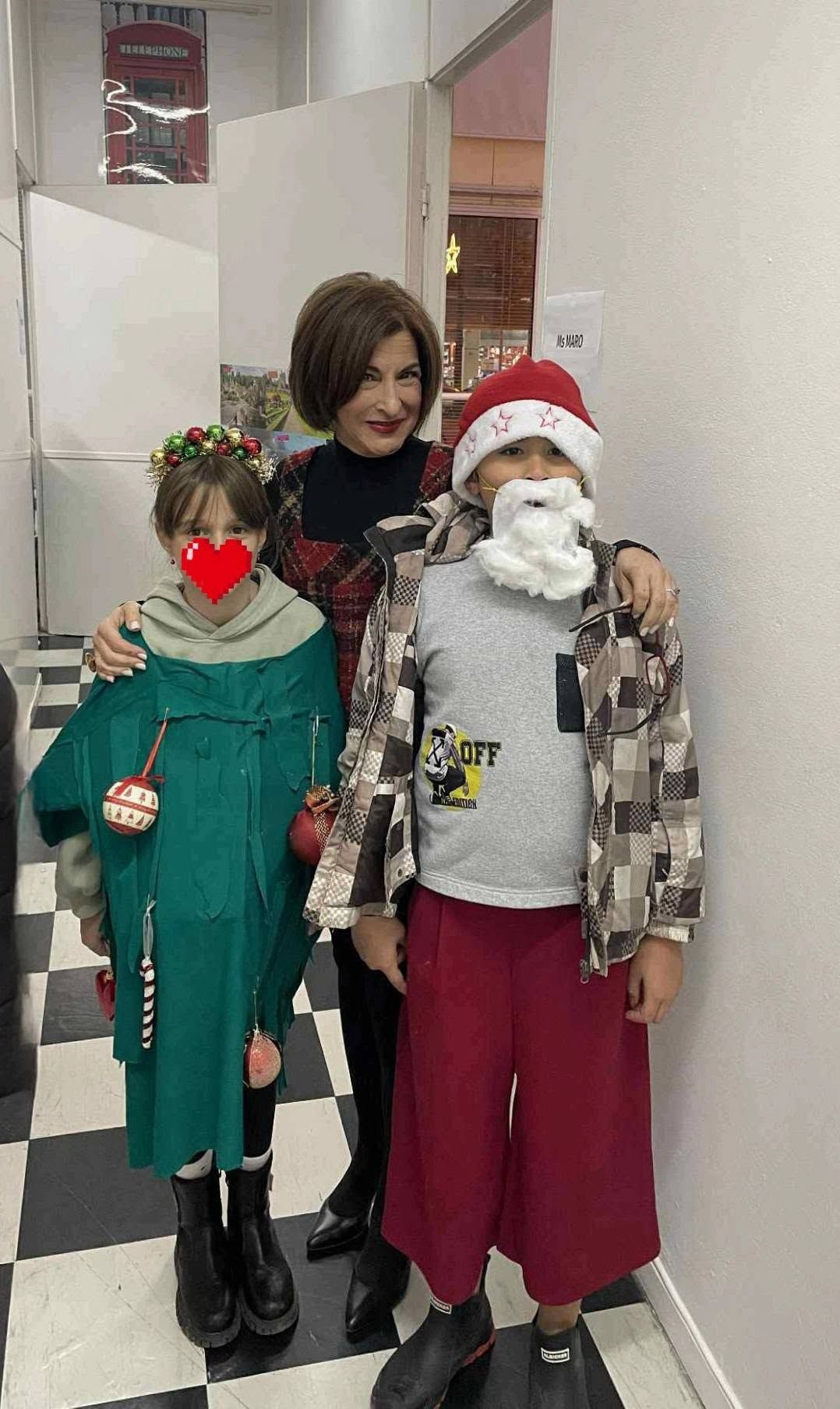 Δύο παιδιά με χριστουγεννιάτικες στολές στον διάδρομο.