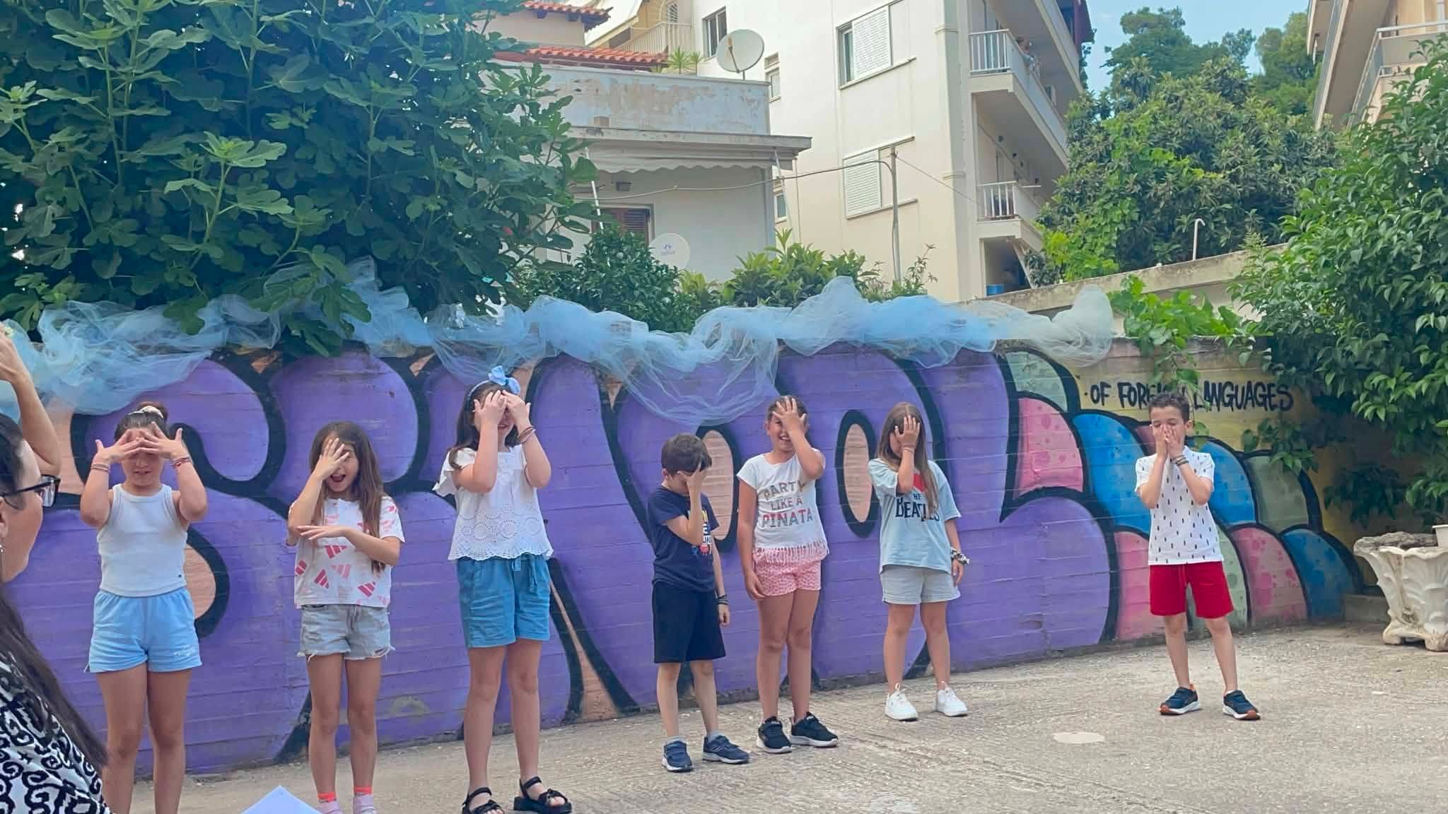 Παιδιά παρουσιάζουν κινητική δραστηριότητα μπροστά στον ζωγραφισμένο τοίχο.